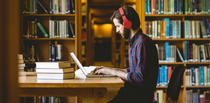 chico estudiando en una biblioteca